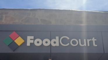 Logo des Food Courts am Unteren Schloss vor blauem Himmel